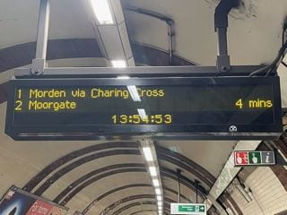 A sign in the underground shows the next trains to arrive